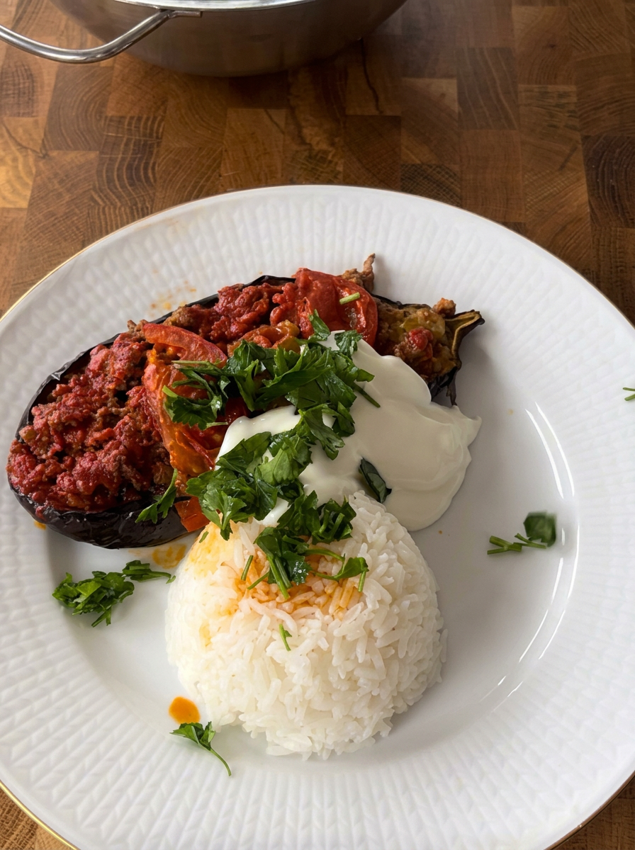 Fylld aubergine med köttfärssås, yoghurt, persilja och ris på en tallrik